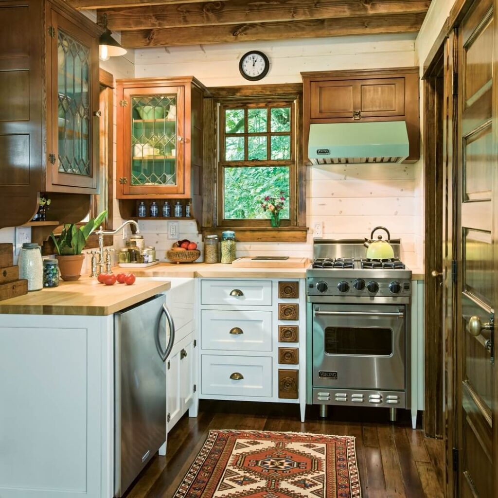 Kuhinja u rustikalnoj kolibi s modernim kuhinjskim uređajima i pogledom na okolnu prirodu