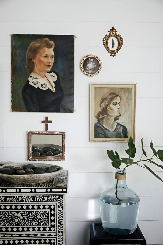 Zid sa slikama iznad komode u dnevnom boravku renovirane kućice u dvorištu