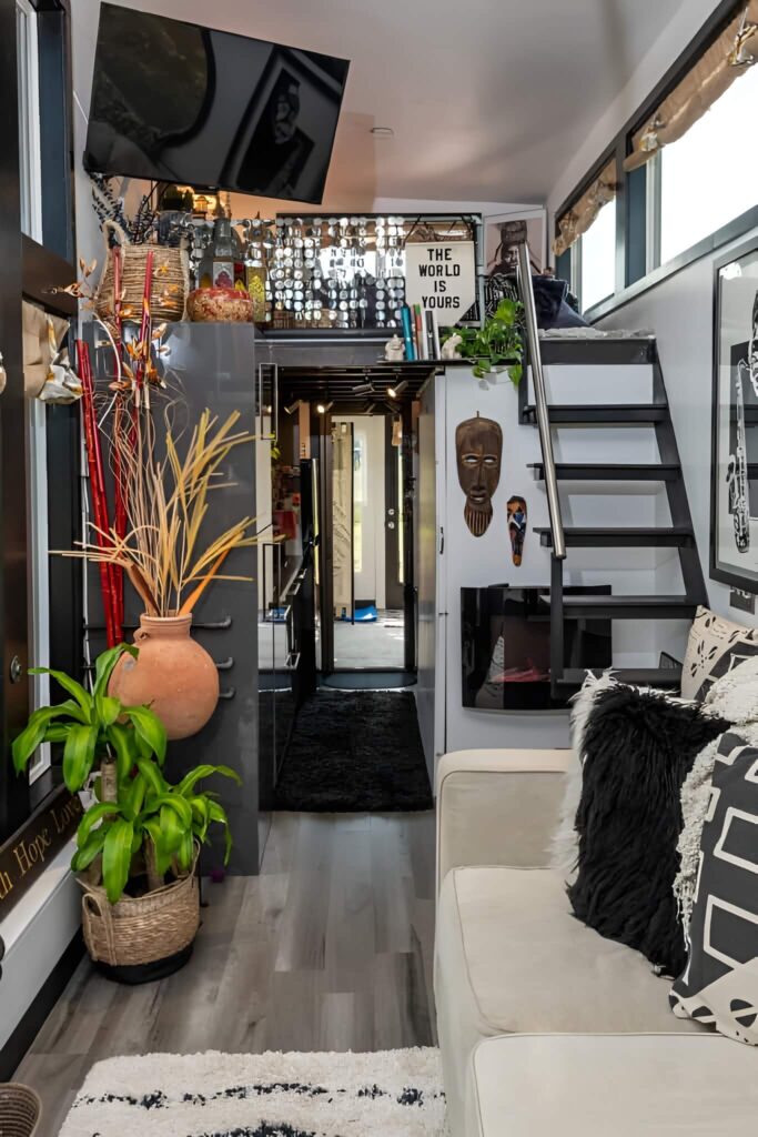 Dnevni boravak boemske kućice s fokusom na stepenice koje vode do potkrovlja sa spuštenim stropom