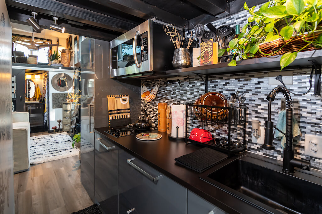 Potpuno opremljena moderna kuhinja tamnih boja u boemskoj kućici