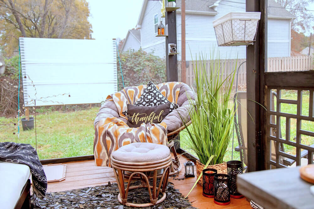 Udobni naslonjač i stolić u sunčanoj sobi boemske kućice u dvorištu