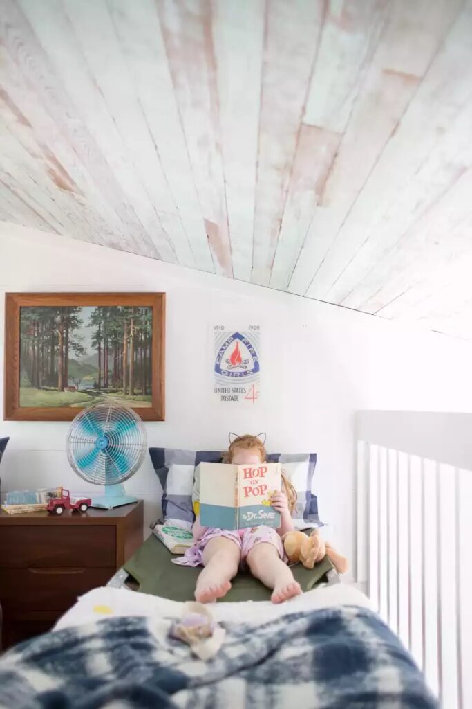 Djevojčica leži na krevetu i čita knjigu za djecu