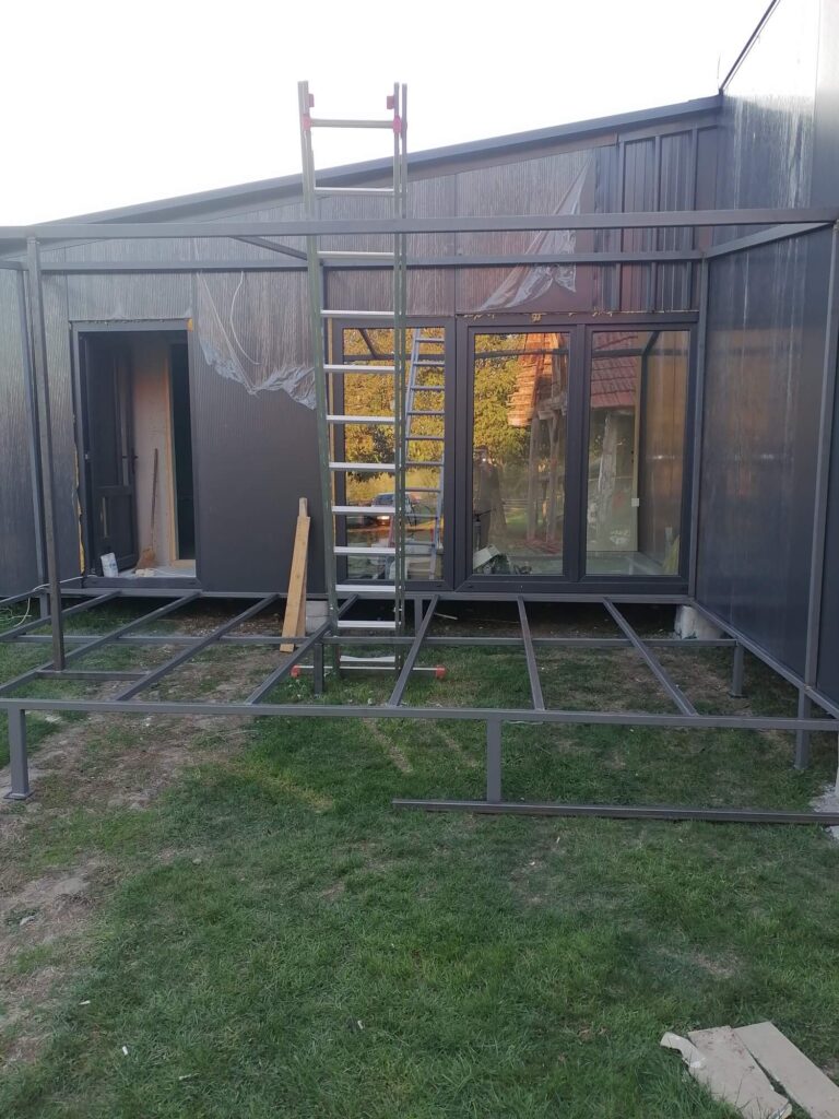 Moderna modularna kućica u izgradnji sa metalnom konstrukcijom terase i merdevinama ispred