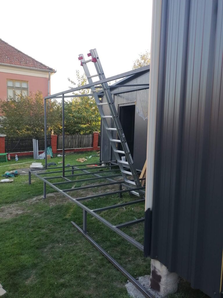 Modularna kućica sa metalnom konstrukcijom terase u izgradnji, sa merdevinama prislonjenim na ulaz