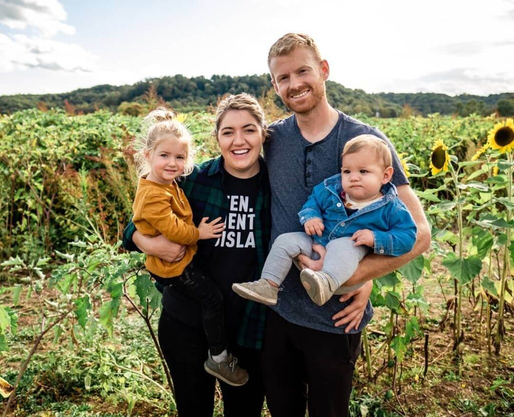 Obitelj s dvoje male djece u polju suncokreta