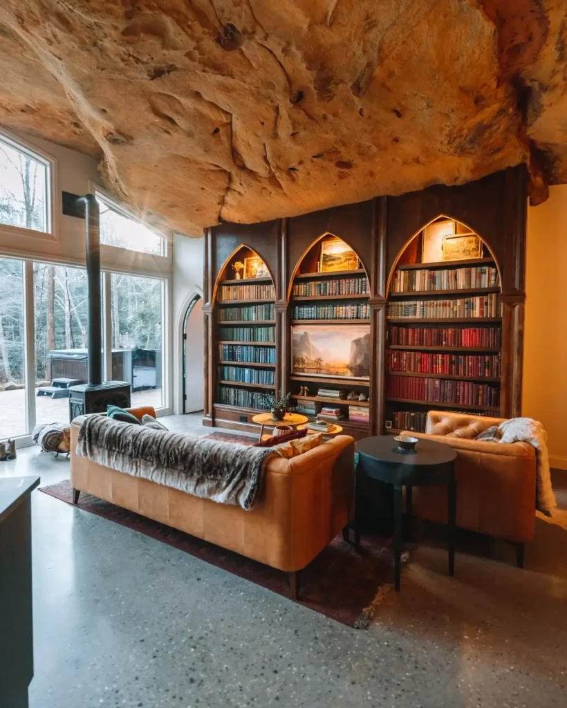 Kamena vikendica s visokim stropom, prozorima, peći na drva, policama za knjige i udobnim kaučem